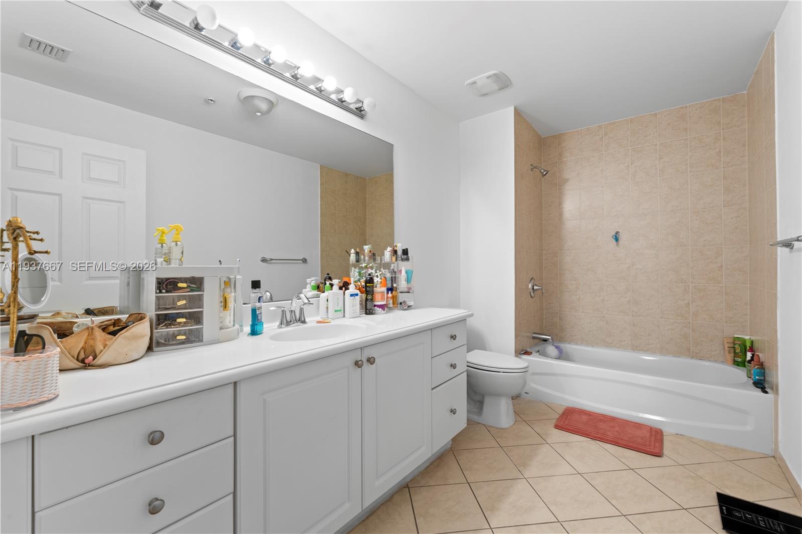8395 Southwest 73rd Avenue, Unit 115 Miami, FL 33143 - Photo 22 of 26 a bathroom with a double vanity sink mirror and toilet