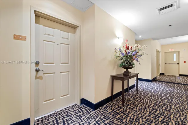 a view of a hallway and a livingroom with furniture