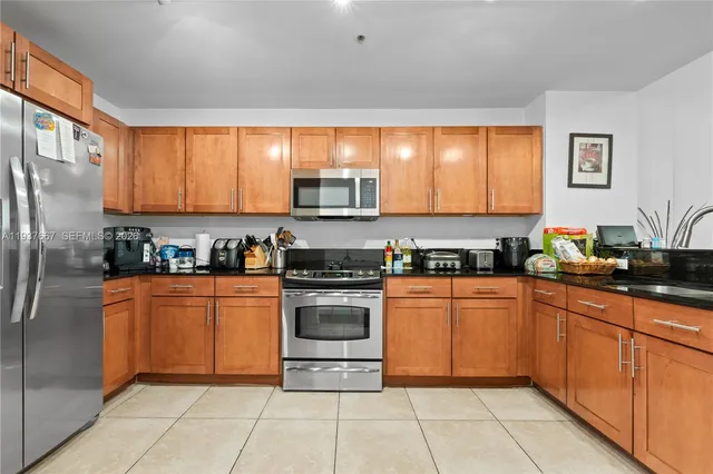 a kitchen with stainless steel appliances granite countertop a stove a sink and a refrigerator
