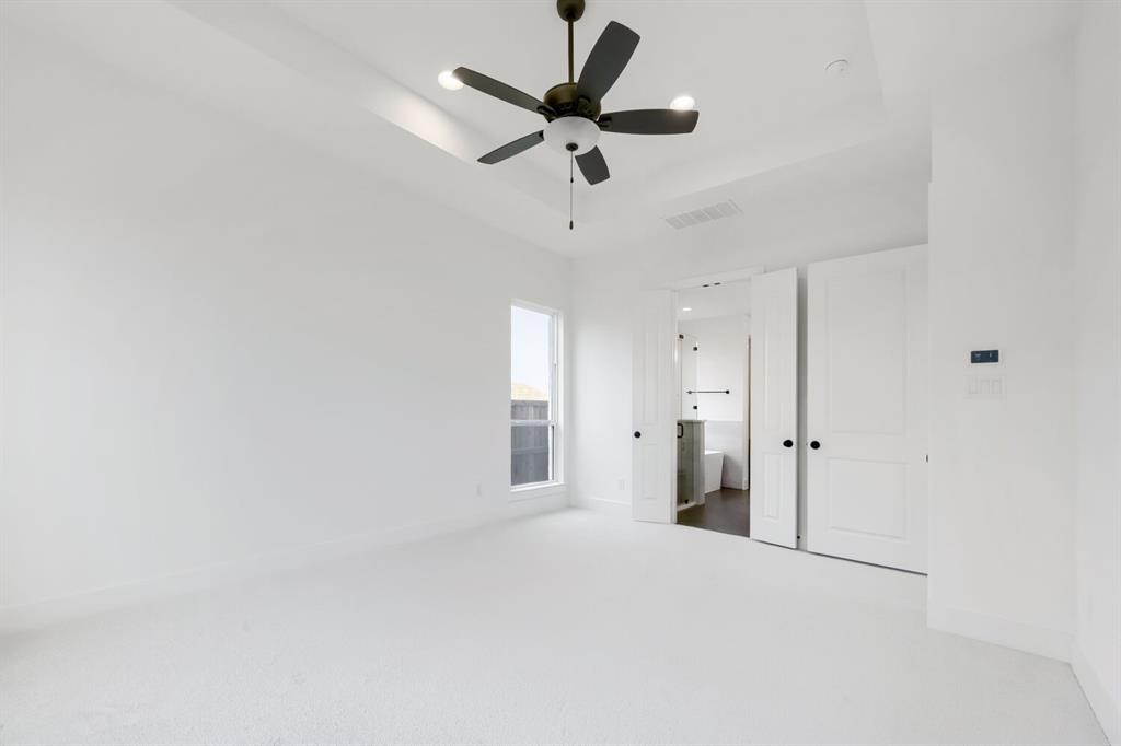 733 Red Cedar Road Haslet, TX 76052 - Photo 14 of 28 Spacious room featuring white carpeting, a tray ceiling with a ceiling fan, and a single window