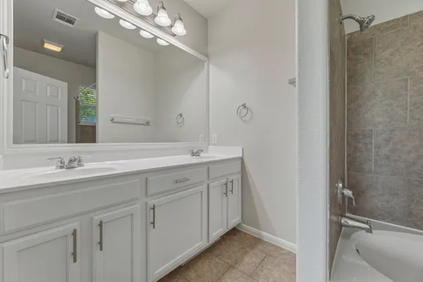 a bathroom with a double vanity sink and a mirror