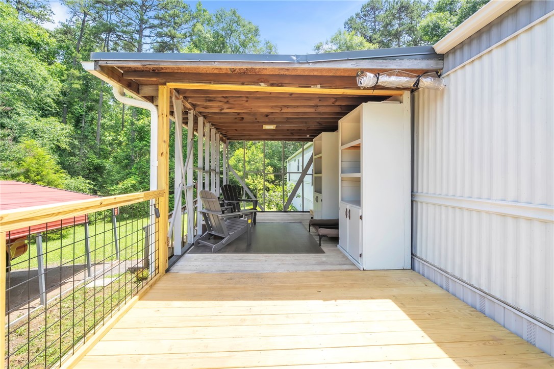 506 Charlies Creek Road Iva, SC 29655 - Photo 22 of 28 A spacious covered deck offers serene forest views, perfect for outdoor relaxation.