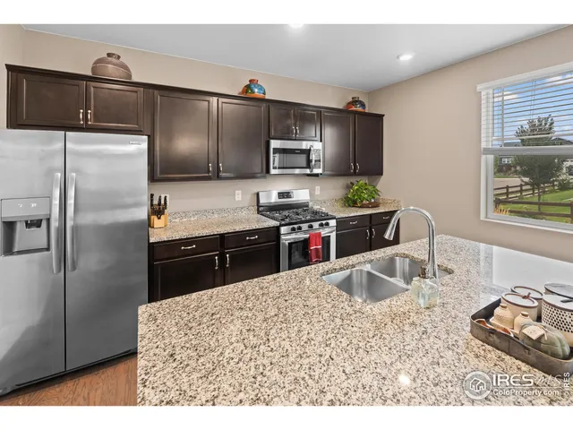 a kitchen with stainless steel appliances granite countertop a sink refrigerator and microwave