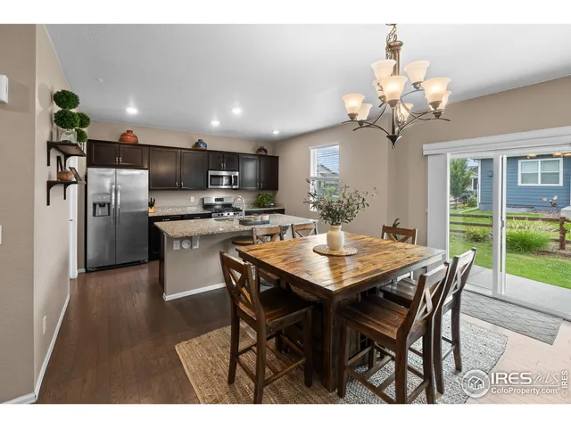 a view of a dining room with furniture a chandelier and wooden floor