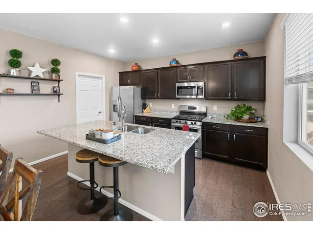 a kitchen with granite countertop a sink cabinets and stainless steel appliances
