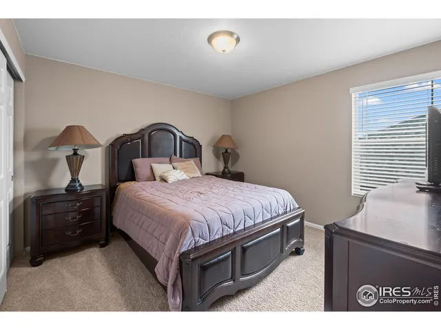 a spacious bedroom with a bed and a dresser