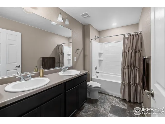 a bathroom with a granite countertop sink toilet a mirror and shower