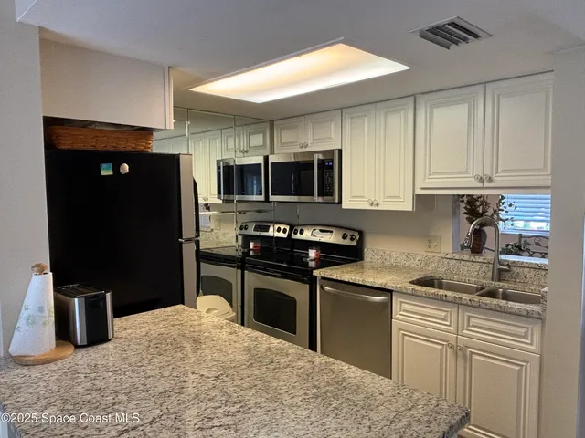 a kitchen with a sink dishwasher stove and refrigerator