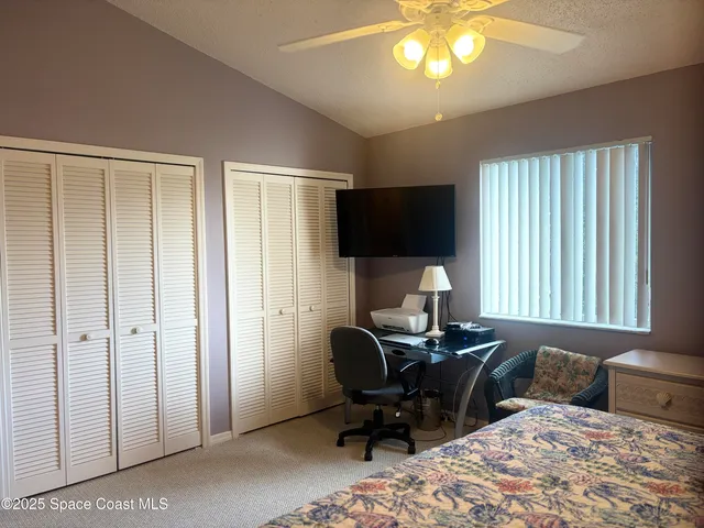 a view of a backyard with table and chairs potted plants and large tree