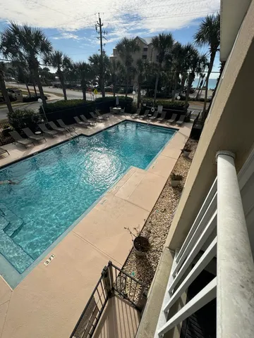 a view of a swimming pool with a bench and trees