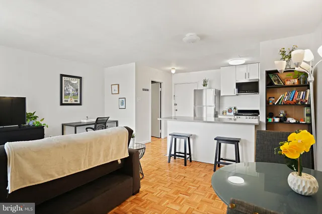 a living room with furniture and kitchen view