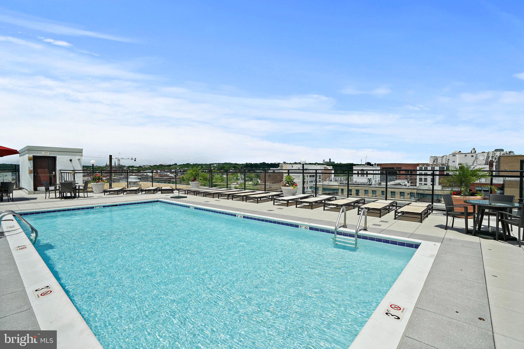 950 25th Street Northwest, Unit 1027N Washington, DC 20037 - Photo 29 of 32 a view of a swimming pool with lawn chairs and a yard