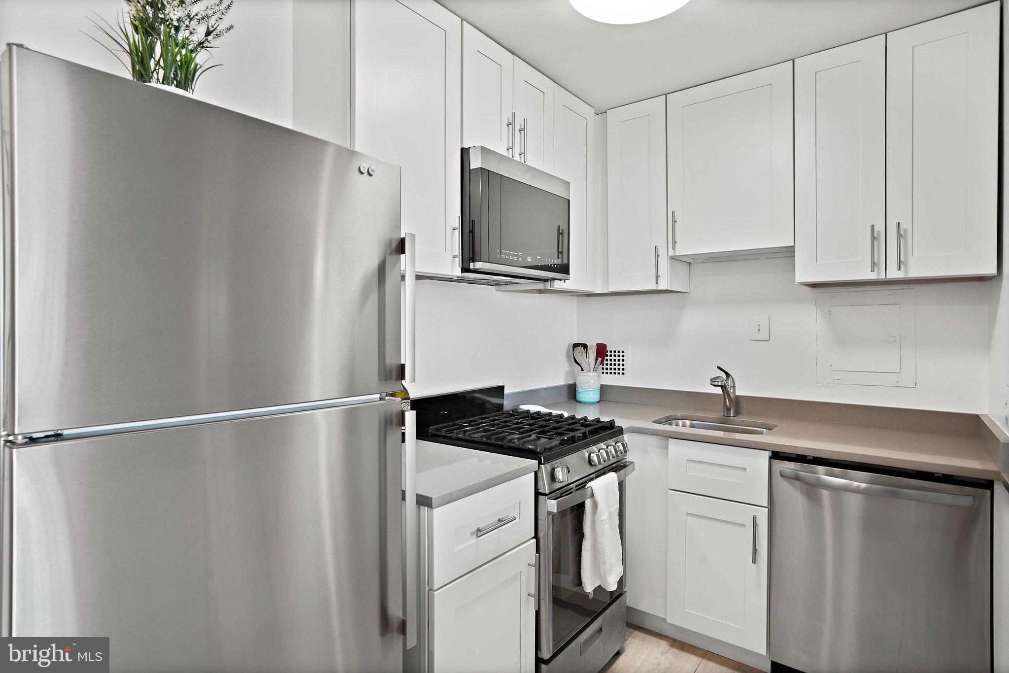 950 25th Street Northwest, Unit 1027N Washington, DC 20037 - Photo 10 of 32 a kitchen with stainless steel appliances white cabinets and a granite counter top