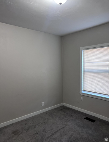 3161 Adams Avenue Ogden, UT 84403 - Photo 10 of 17 Neutral-toned room featuring a single window with blinds, ceiling-mounted light fixture, and gray carpeting