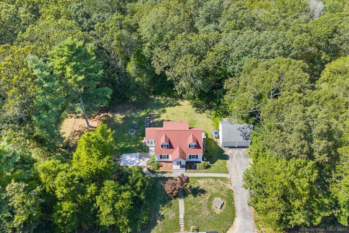 an aerial view of residential house with outdoor space and trees all around