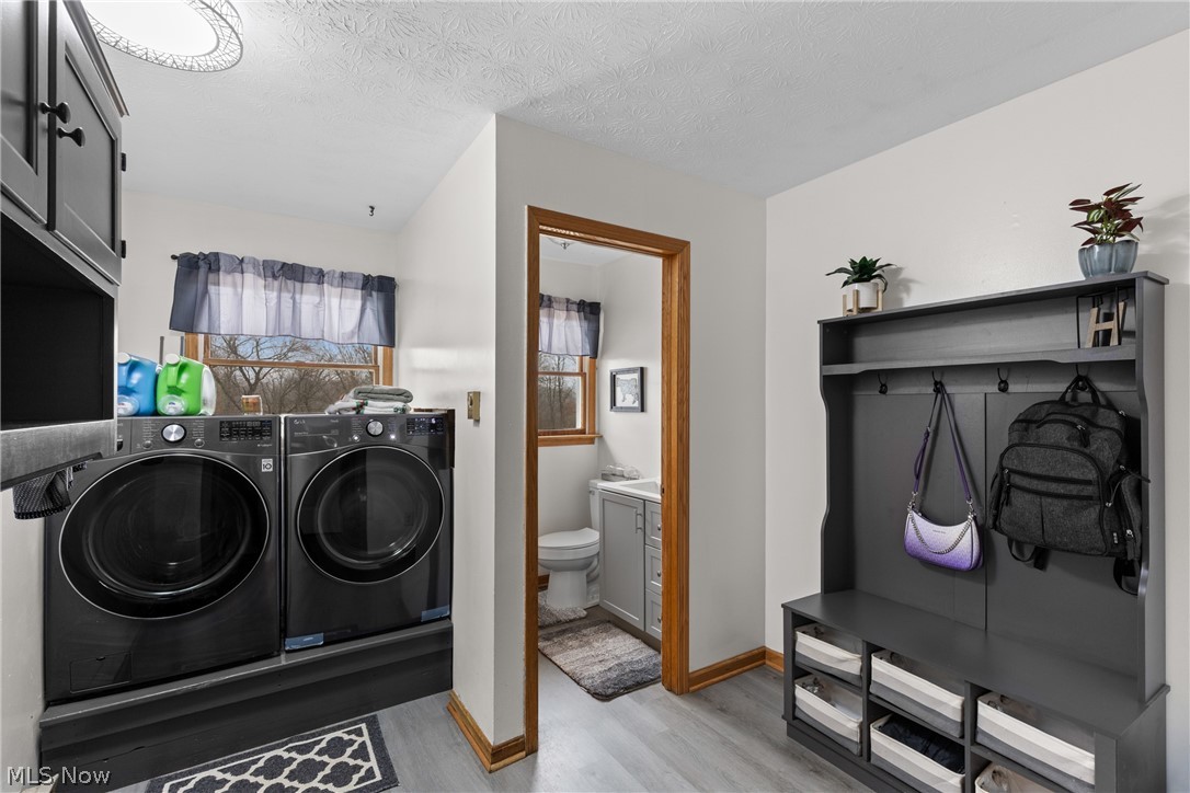 64508 Slade Road Cambridge, OH 43725 - Photo 22 of 50 Laundry room with a textured ceiling, washing machine and dryer, and light wood-style flooring