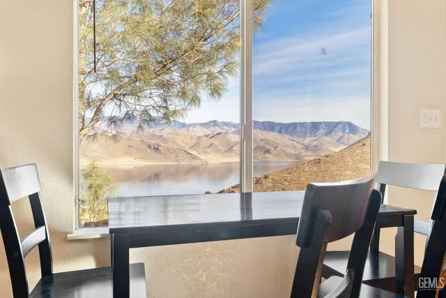 a kitchen with stainless steel appliances granite countertop a stove top oven a sink dishwasher and a dining table with wooden floor