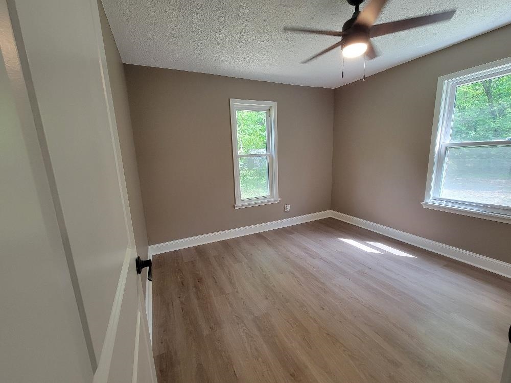 913 Chambliss Road Memphis, TN 38116 - Photo 13 of 16 Spacious room featuring light wood-finish flooring, neutral wall paint, white trim, and a ceiling fan with integrated lighting