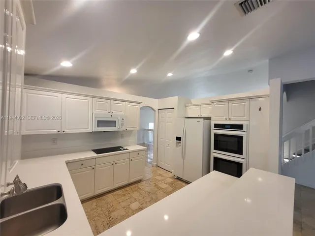 a kitchen with white cabinets and stainless steel appliances