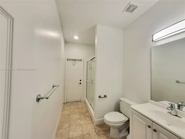 a bathroom with a granite countertop sink a toilet and a mirror