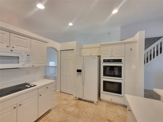 a kitchen with granite countertop a refrigerator and a sink