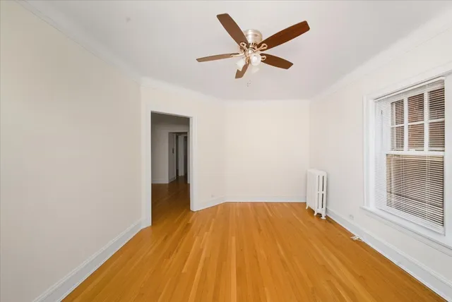 a view of a room with wooden floor and a ceiling fan