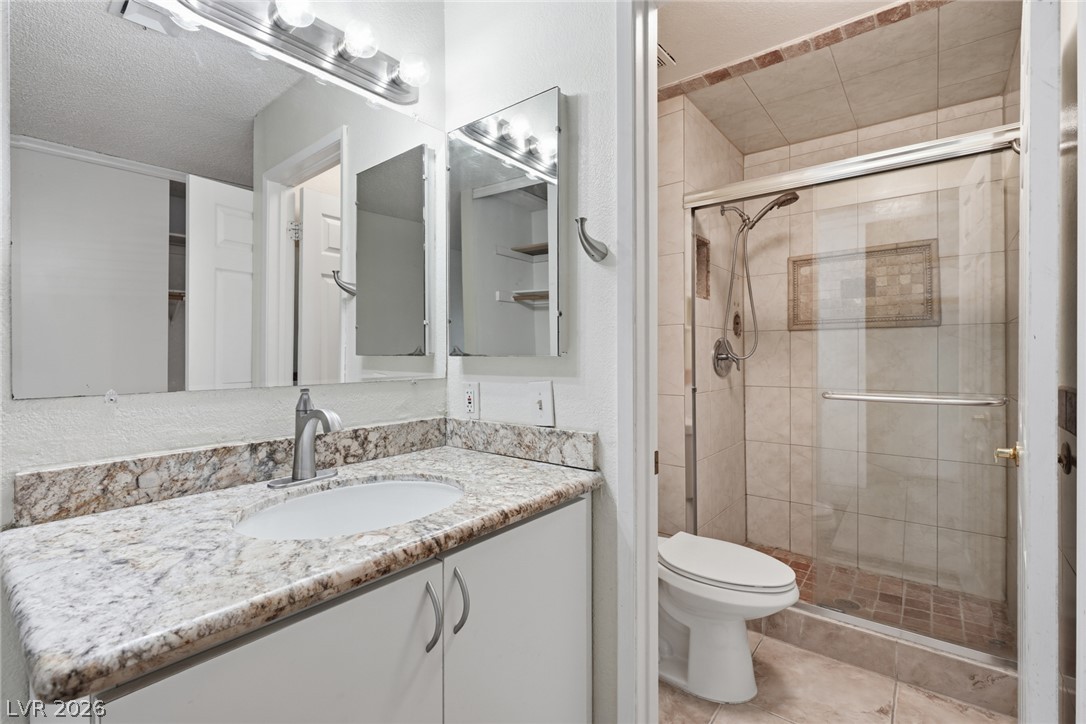 3971 Spring Leaf Drive Las Vegas, NV 89147 - Photo 19 of 48 Marble-look countertops highlight a pristine single vanity and an adjacent tiled shower.