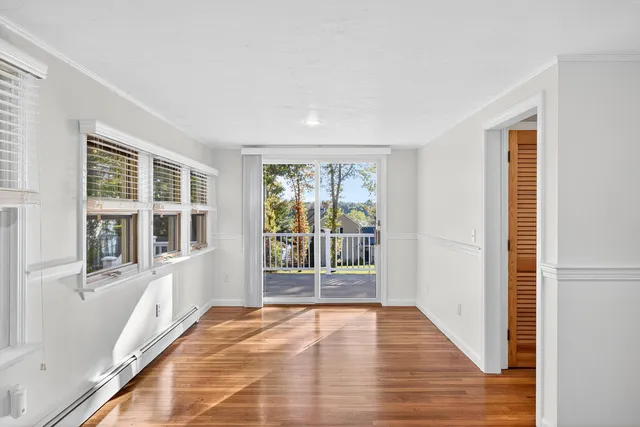 a view of a livingroom with wooden floor fireplace and windows