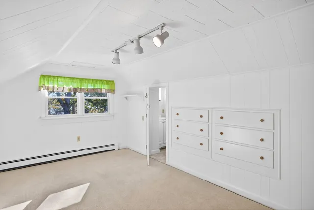 a view of a tiny house with a small yard and large trees