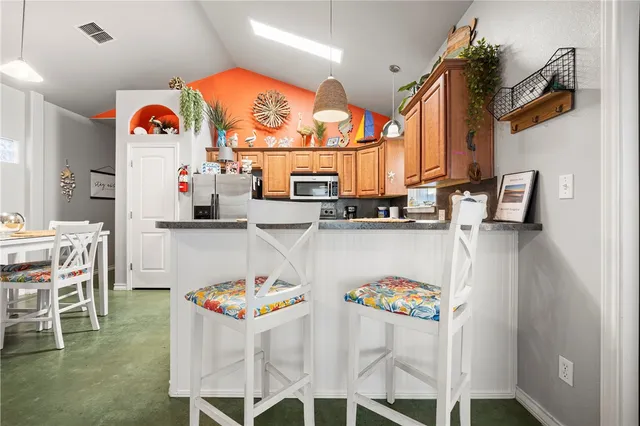 a kitchen with stainless steel appliances kitchen island granite countertop a refrigerator and microwave