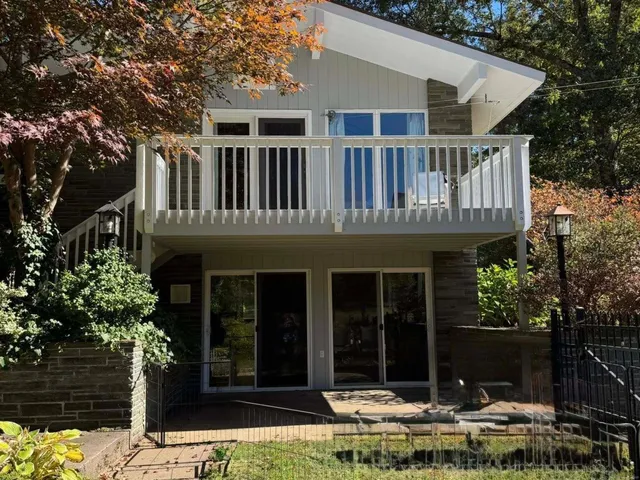a front view of a house with a tree
