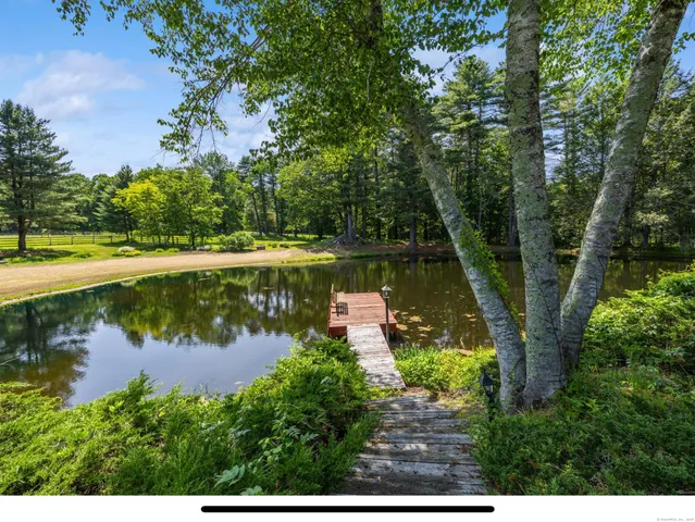 a kitchen with stainless steel appliances a sink a stove a refrigerator cabinets and wooden floors