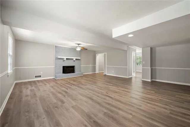 a view of empty room with wooden floor and fireplace