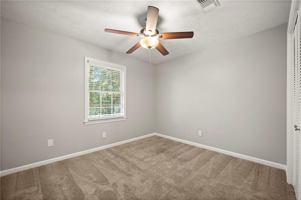 215 Hauteur Place Southwest Lilburn, GA 30047 - Photo 9 of 12 an empty room with a window and a fan