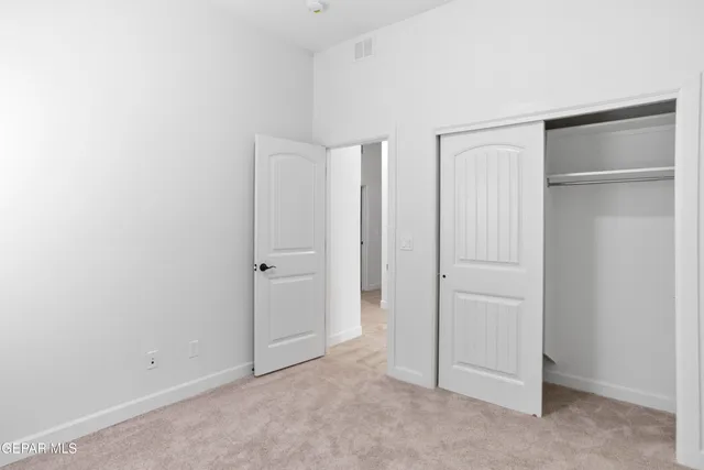 an empty room with ceiling fan and window
