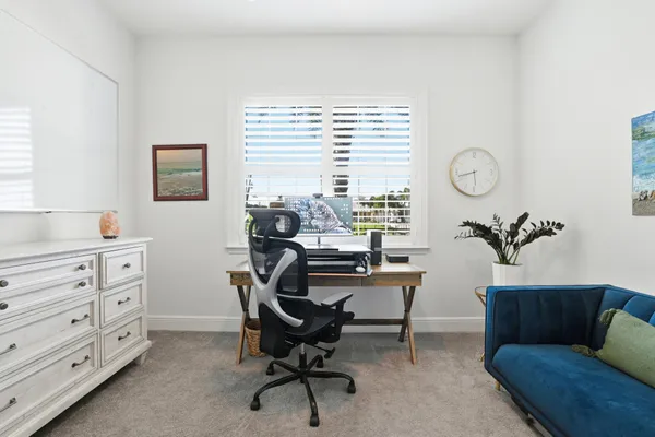 a view of a workspace with furniture and a window