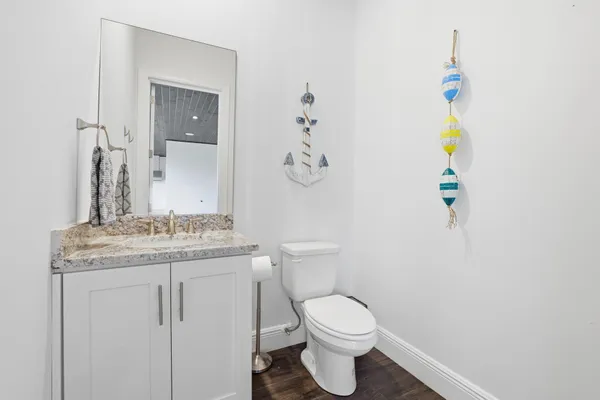 a bathroom with a granite countertop sink toilet and a mirror