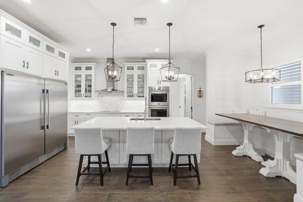 9301 154th Road North Jupiter, FL 33478 - Photo 5 of 39 a kitchen with stainless steel appliances kitchen island granite countertop a table chairs and a wooden floors