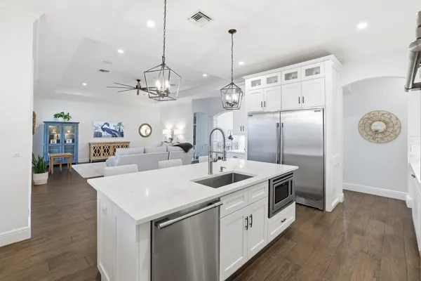 a kitchen that has a lot of cabinets and wooden floor