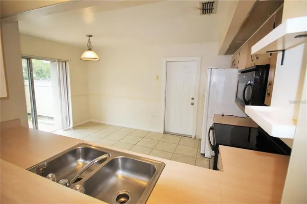 a view of a kitchen with a sink and a refrigerator