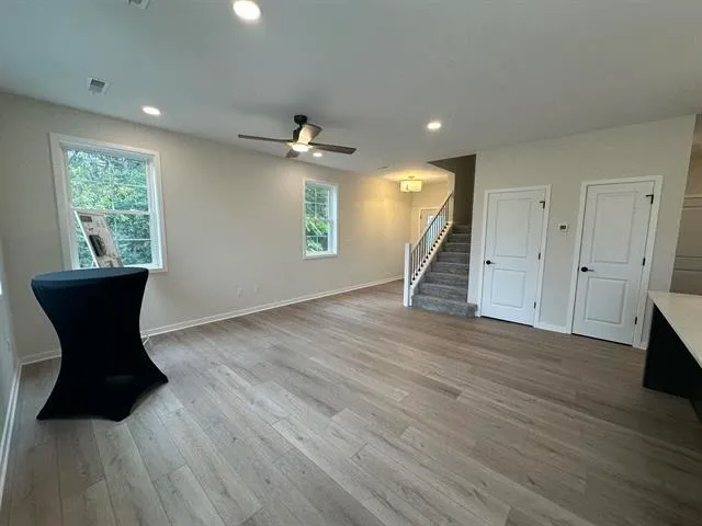 a view of a livingroom with wooden floor and furniture
