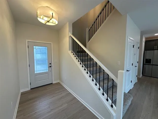 a view of a hallway with wooden floor and staircase