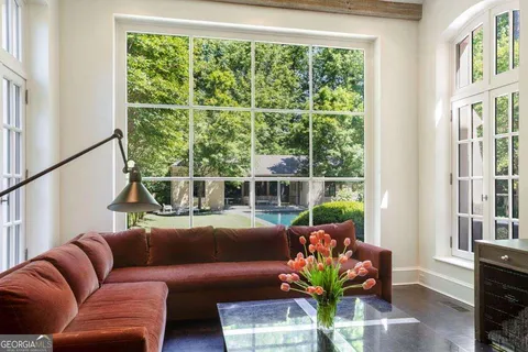 a bedroom with a bed and large windows