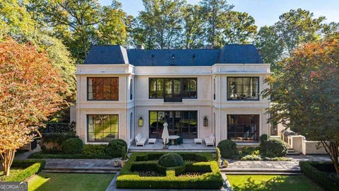 a front view of a house with swimming pool and a yard table and chairs