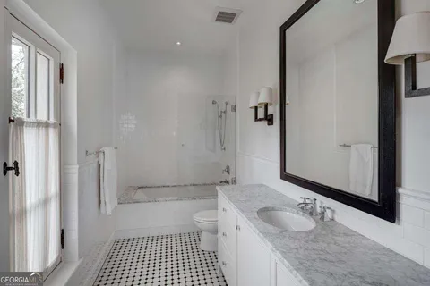 a spacious bedroom with a bed and a couch next to a window