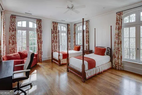 a bedroom with a bed and large windows