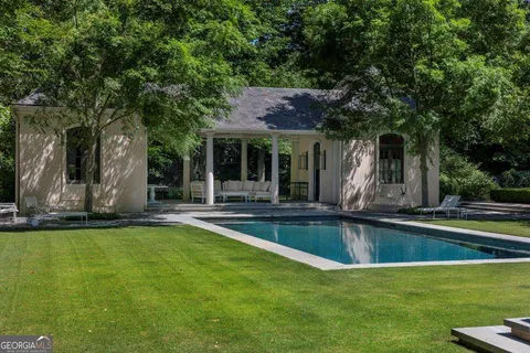 a view of a swimming pool and a table and chairs in patio
