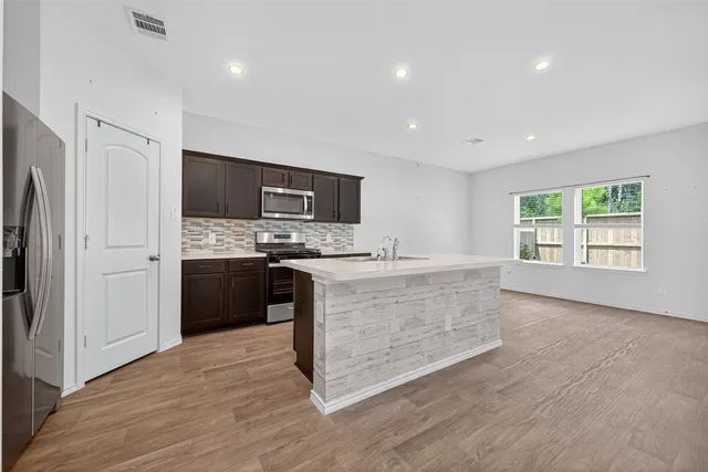 a large kitchen with a stove a refrigerator and a sink
