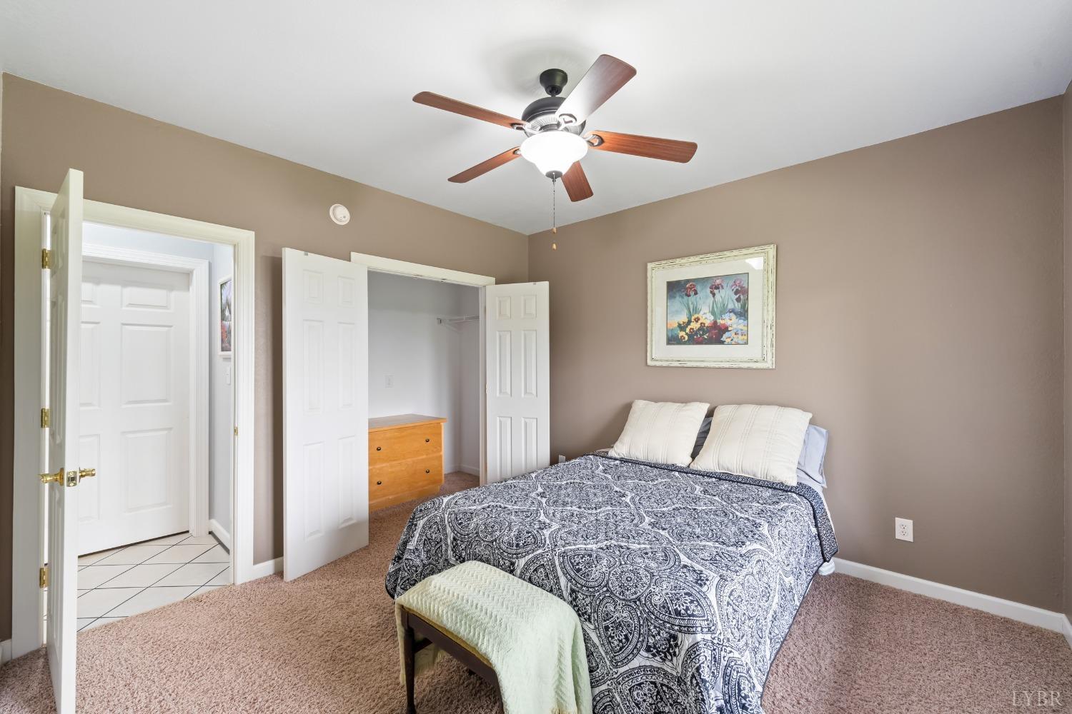 1136 Heavens View Drive Goode, VA 24556 - Photo 36 of 60 a bedroom with a large bed and a chandelier