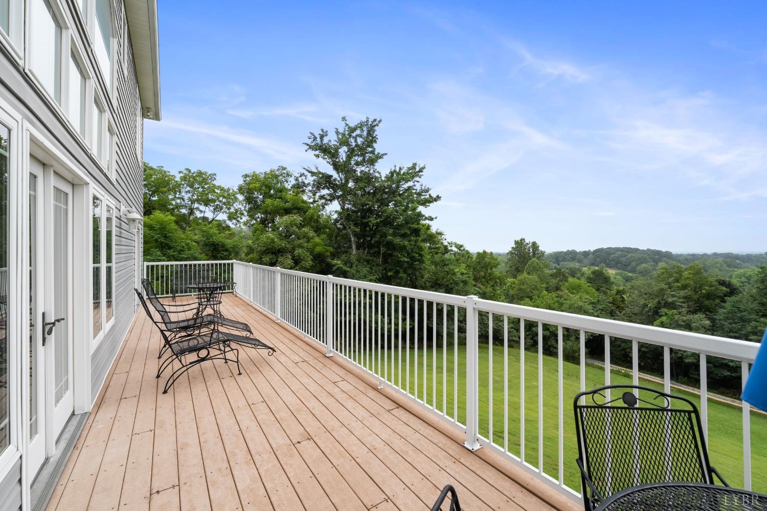 1136 Heavens View Drive Goode, VA 24556 - Photo 5 of 60 a view of a balcony with two chairs and wooden floor